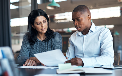 Two people reviewing financial documents