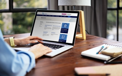 Closeup of a person working on a laptop with the TRA resources landing page on screen