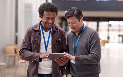 Teacher and administrator looking at a tablet together in a school hallway